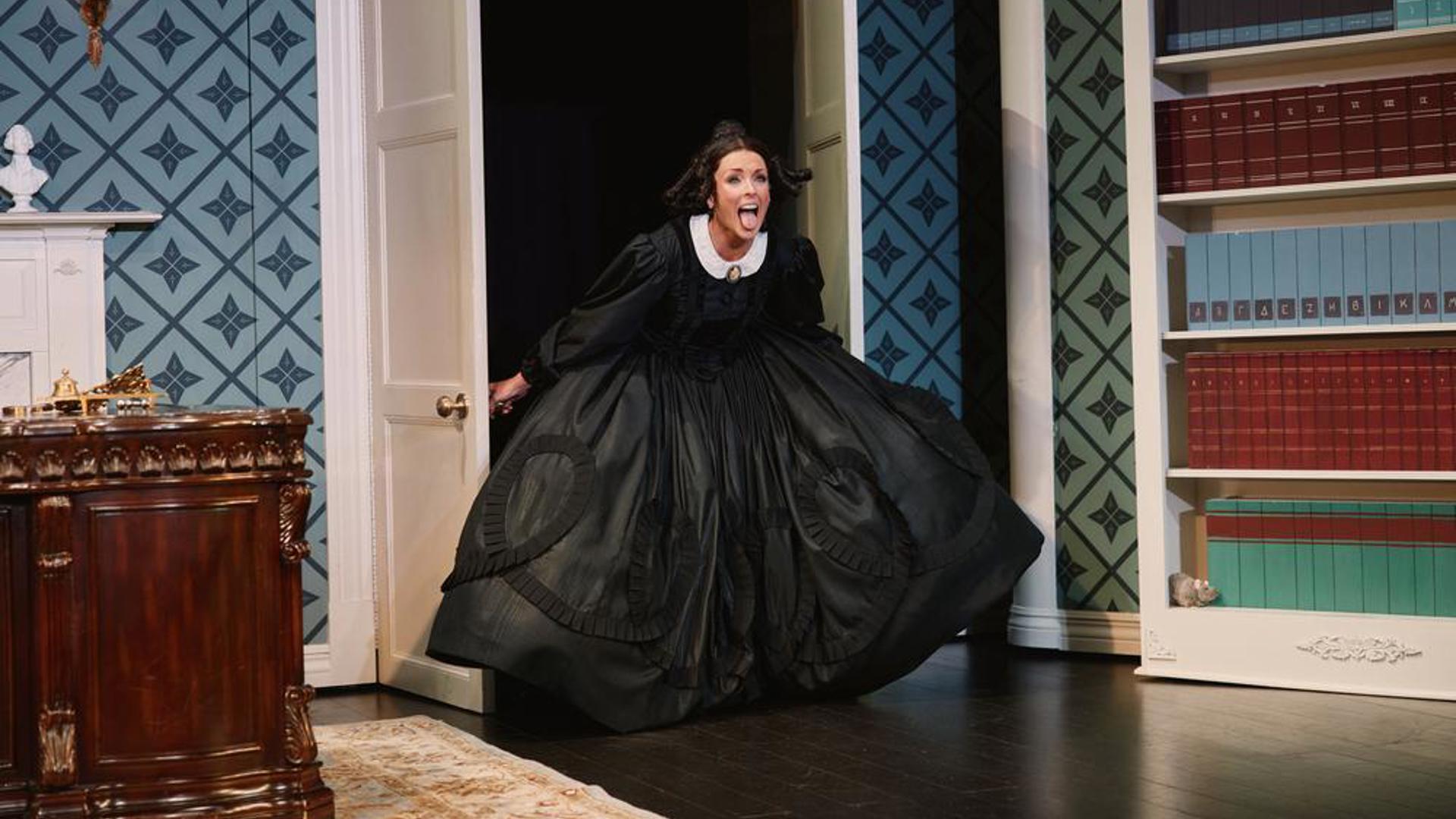 A performer running through open doors with her tongue sticking out.