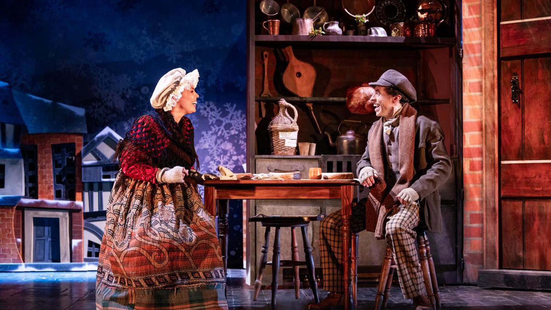 Two performers sitting across the table from each other.