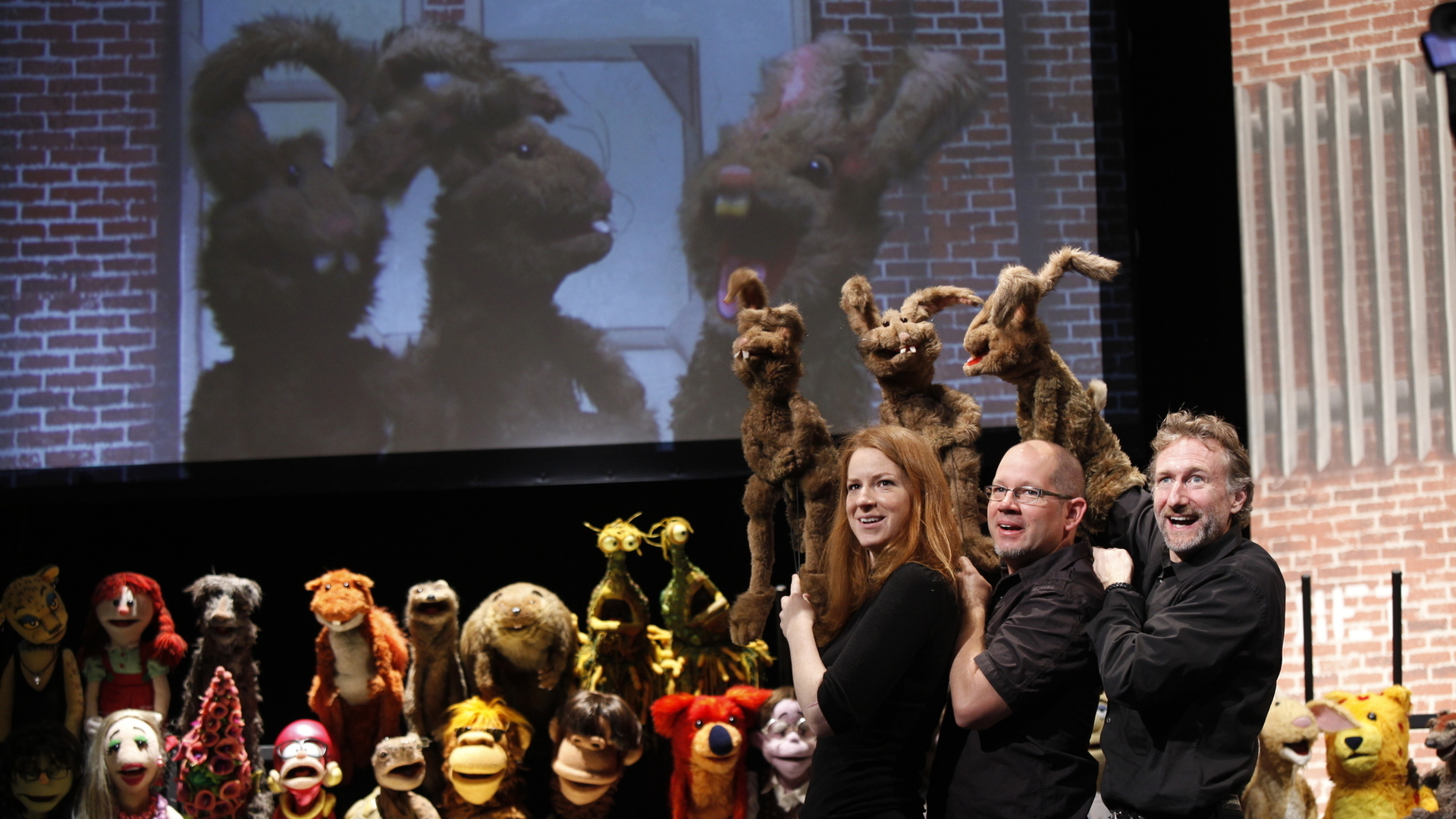 three puppeteers with puppets performing