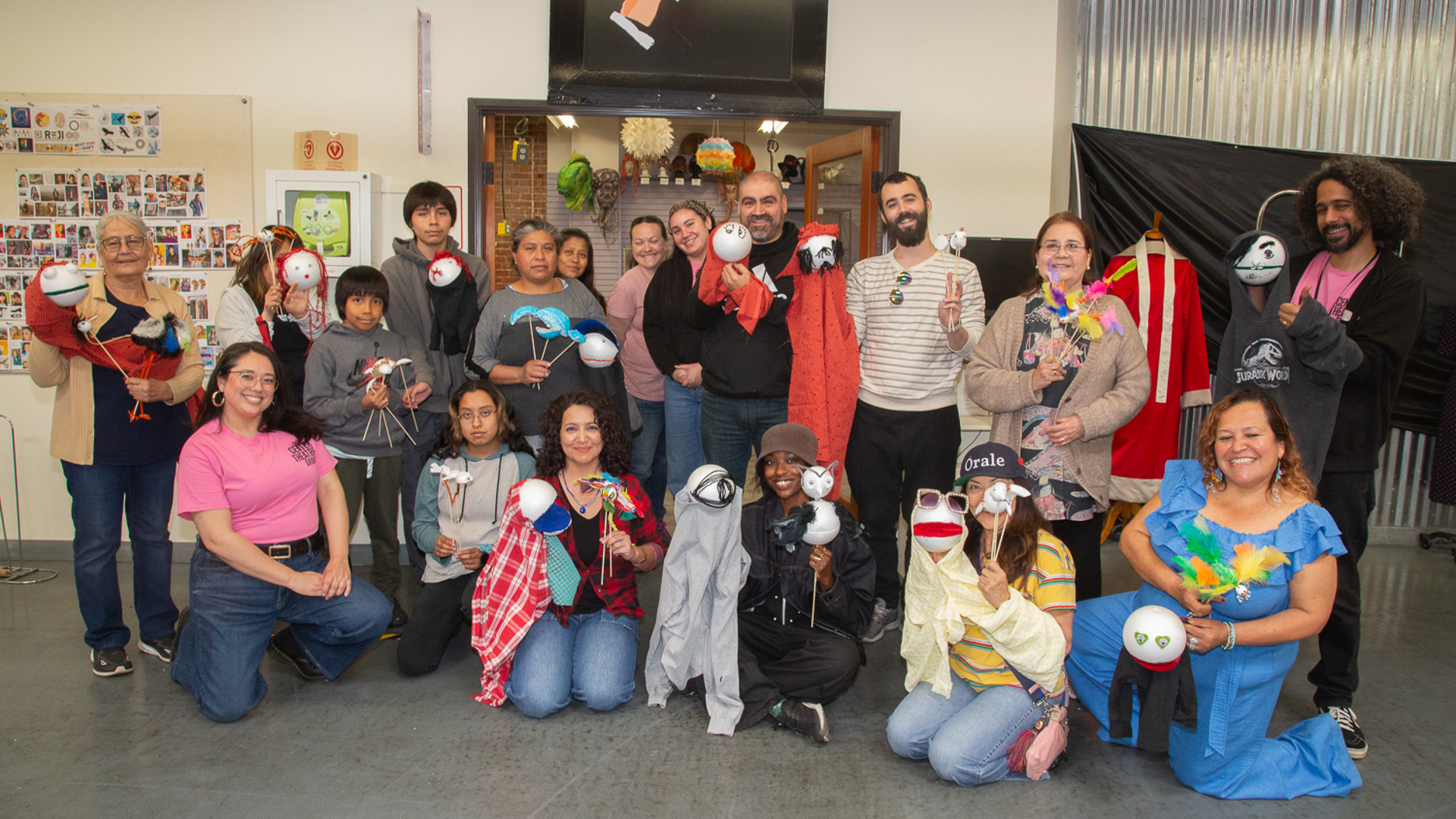 Group of participants posing together while holding handmade puppets.